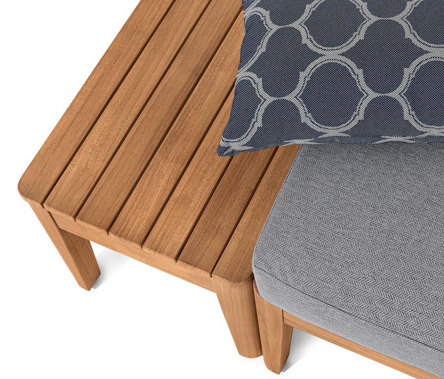 Detail einer Teak-Lounge-Ecke mit blauem Kissen.
