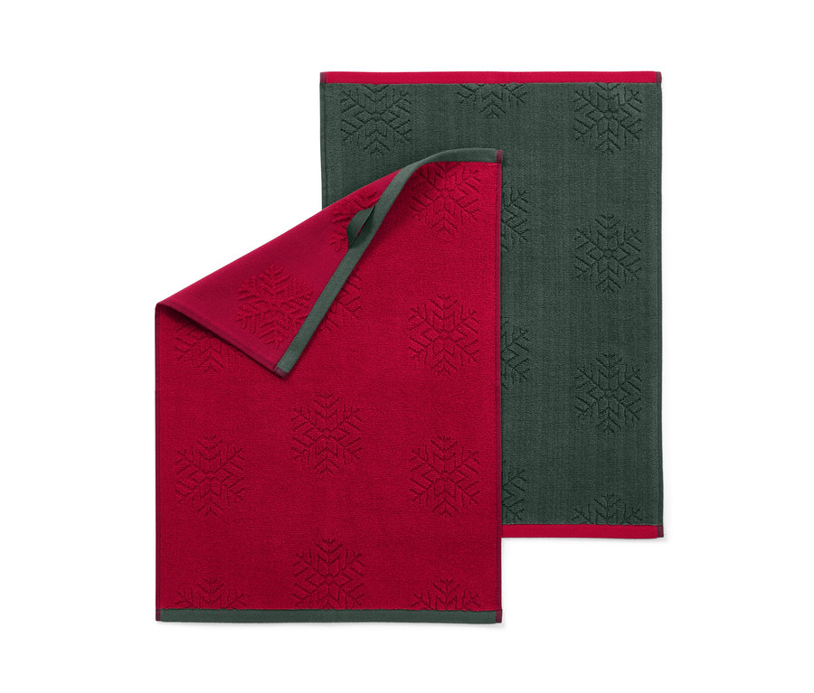 Zwei Küchenhandtücher mit Schneeflockenmuster, eins rot, eins dunkelgrün.