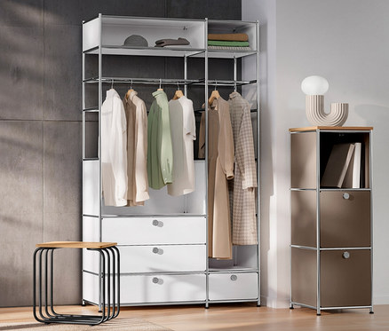 Innenraum mit weißer Tür, Kommode Metall »CN3« mit 2 Kleiderstangen und 4 Schubladen, schmaler Kommode Metall »CN3« mit Holzplatte, taupe, LED-Design-Tischleuchte und Hocker.