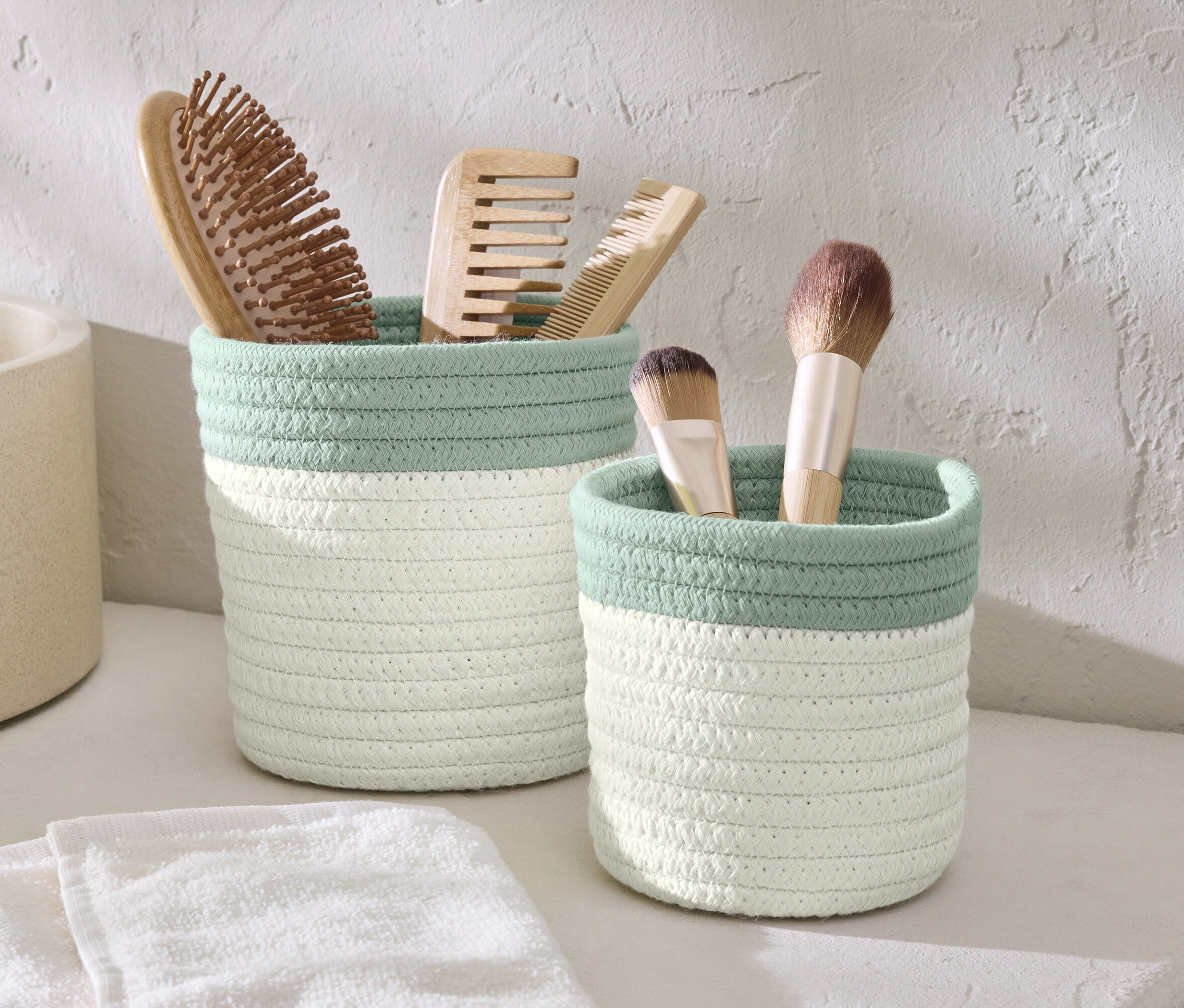 Zwei Aufbewahrungskörbe mit Bürsten und Schminkpinseln.