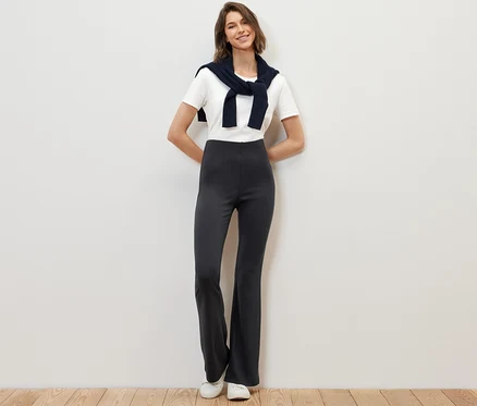Frau posiert stehend in ausgestellten Leggings.