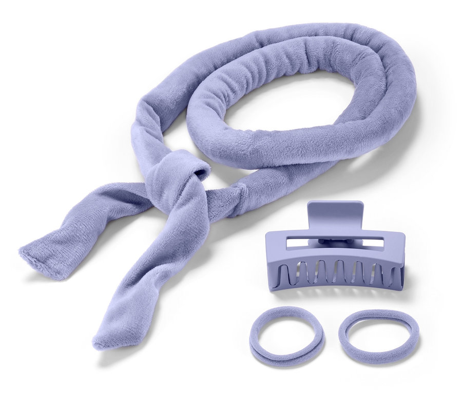 Ein lilafarbener Frottee-Lockenwickler, eine Haarspange und zwei Haargummis auf weißem Hintergrund.