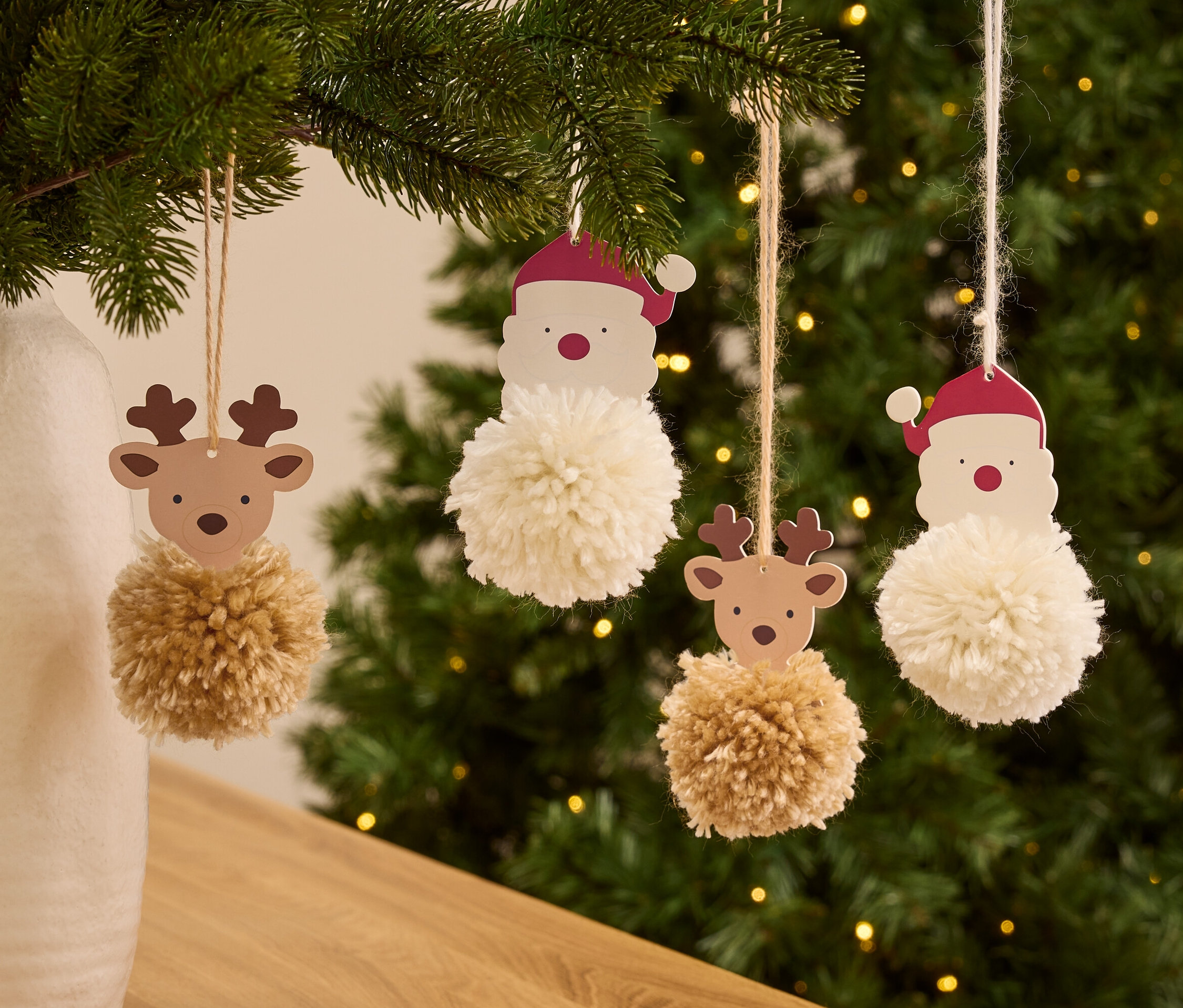 Am Weihnachtsbaum hängen Christbaumschmuck mit Weihnachtsmann- und Rentier-Motiven und Bommeln.
