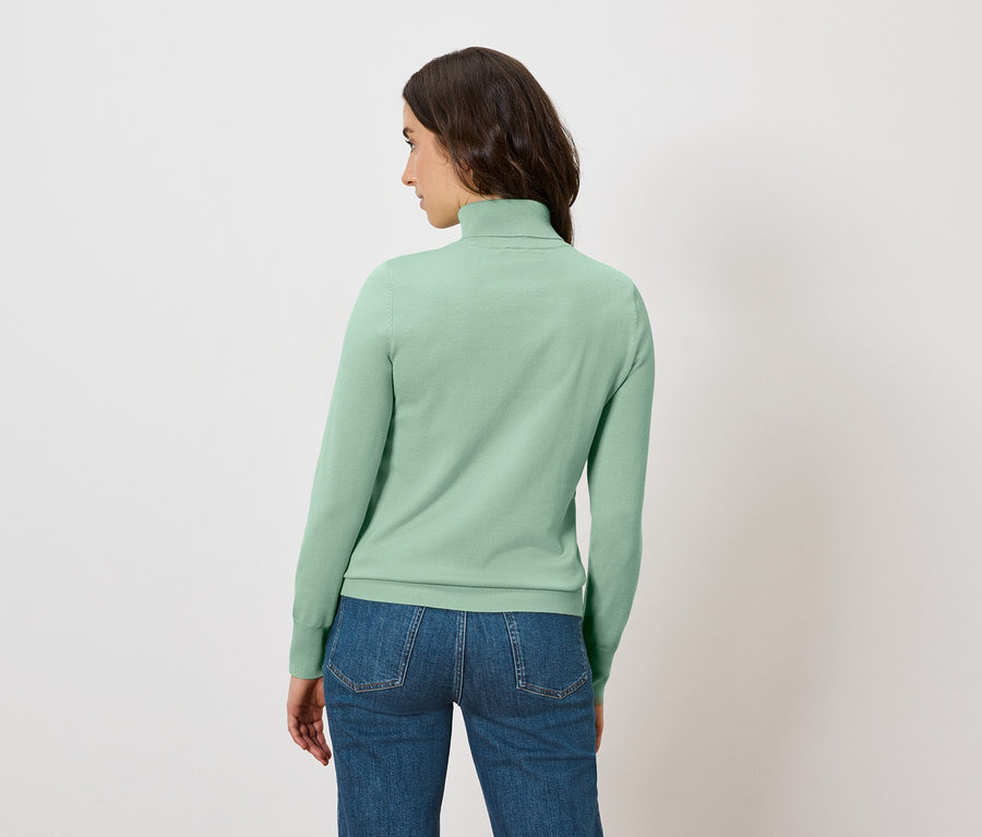 Frau von hinten trägt einen hellgrünen Rollkragenpullover und Jeans.