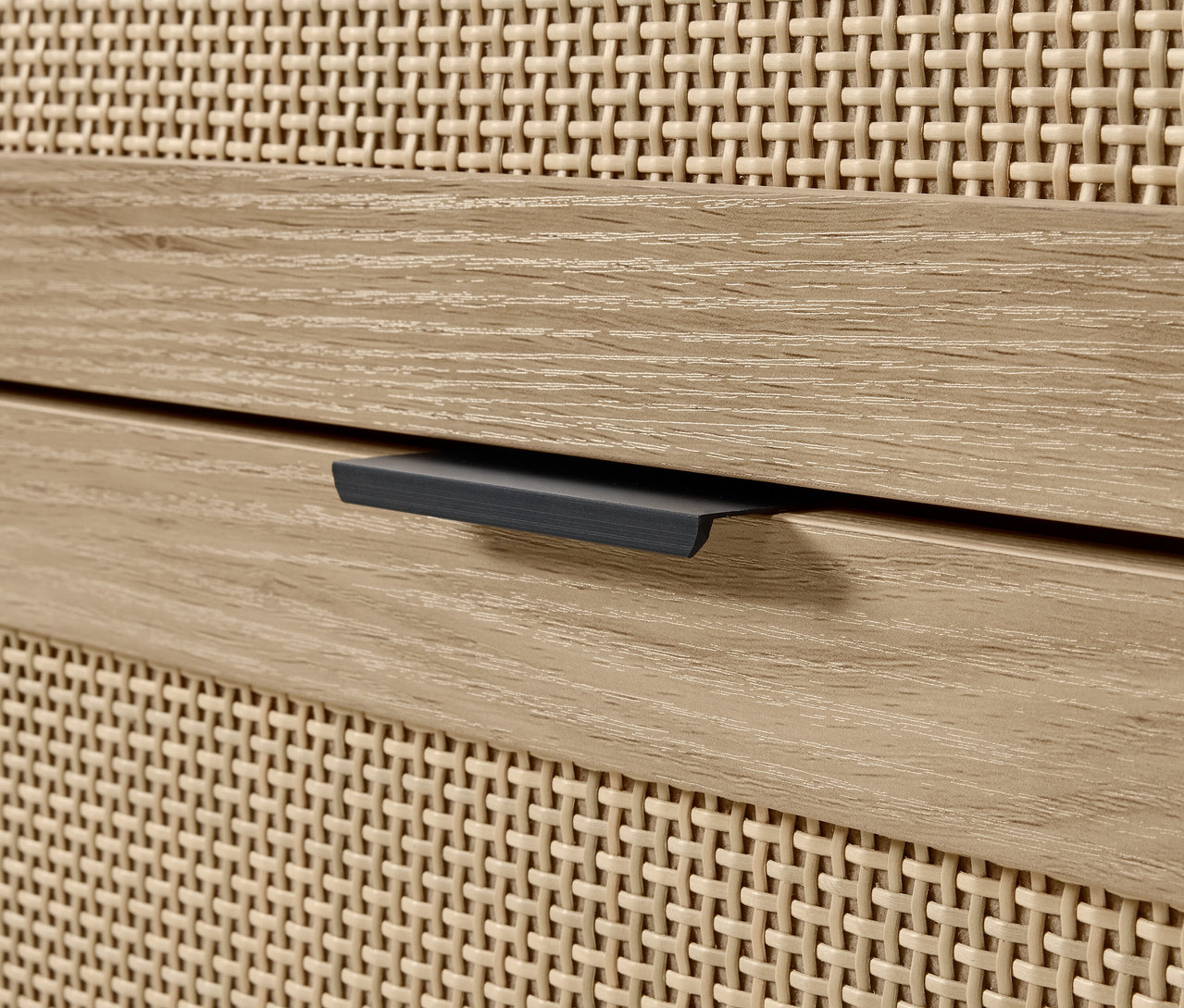 Detail einer Kommode mit Holzschublade und geflochtener Front.