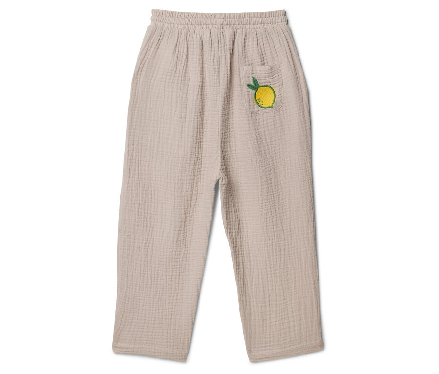 Beige Stoffhose mit Gummibund und aufgesetzter Tasche mit Zitronenapplikation.