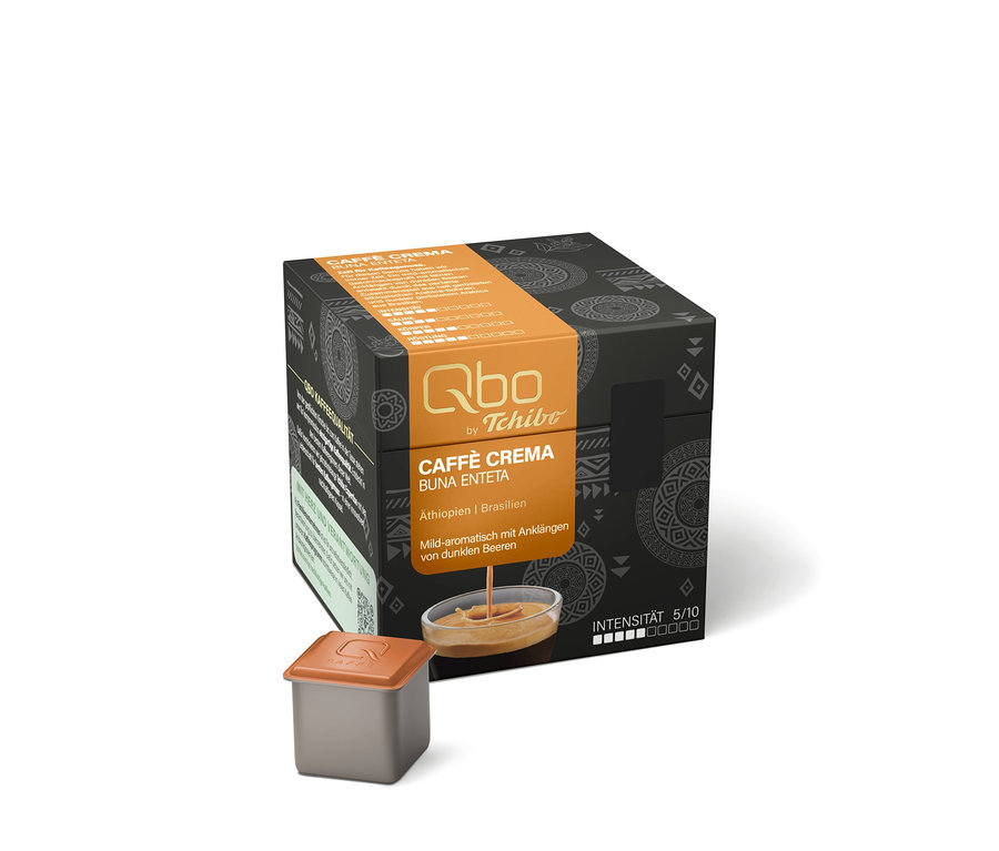 Schwarze Qbo Caffè BUNA ENTETA Kapselpackung mit orangefarbenem Band, daneben eine Kapsel und ein Schälchen mit Kaffeestrahl.