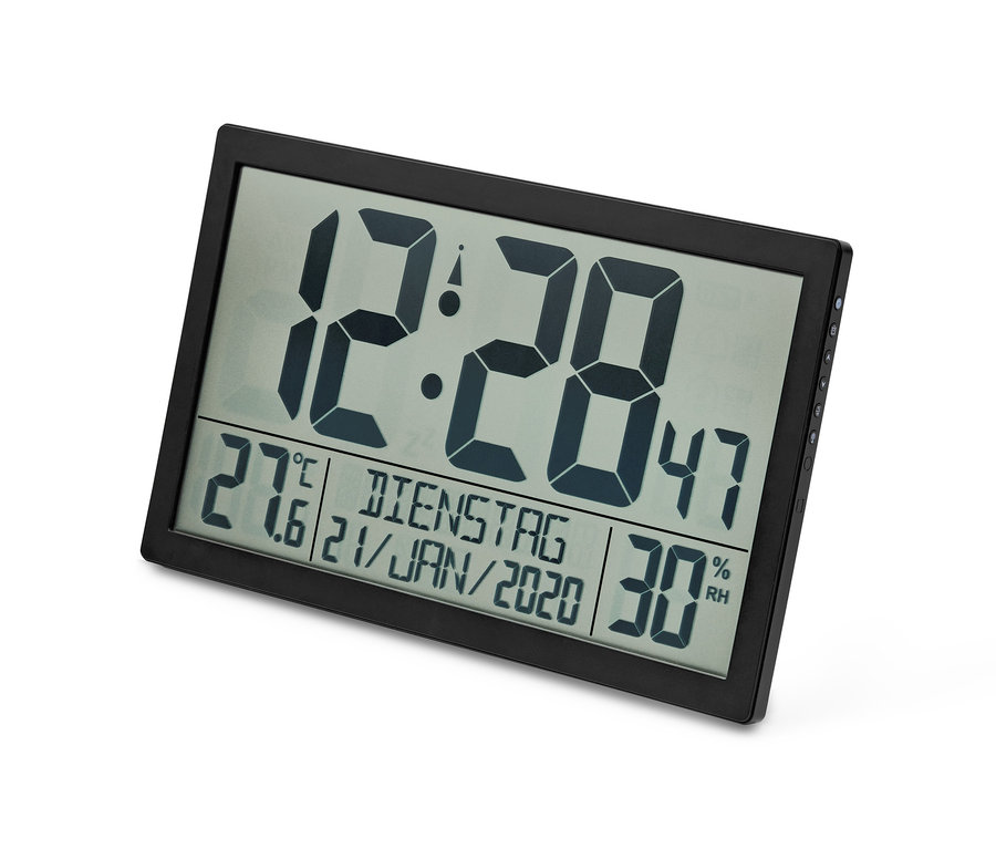 Eine digitale XXL-Funkuhr mit schwarzem Rahmen zeigt die Uhrzeit 12:28, 27,6 Grad Celsius und 30% Luftfeuchtigkeit an.