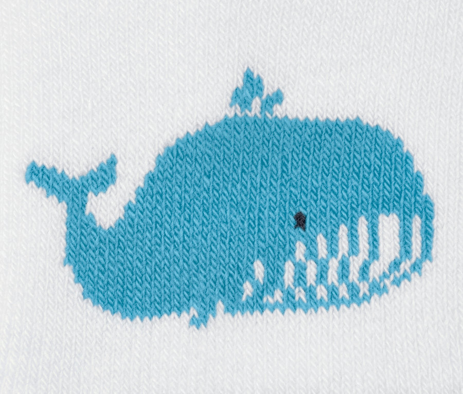 Detail einer Baby-Frottier-Socke mit blauem Wal-Motiv.