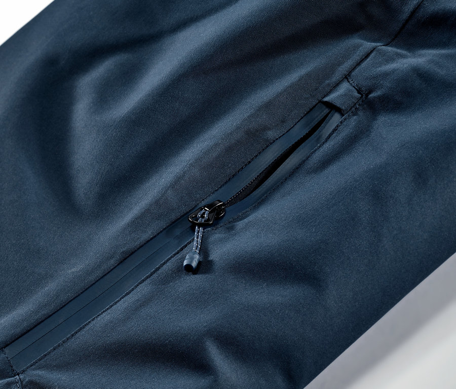 Detailaufnahme einer marineblauen Ski- und Snowboardhose mit Reißverschlusstasche.