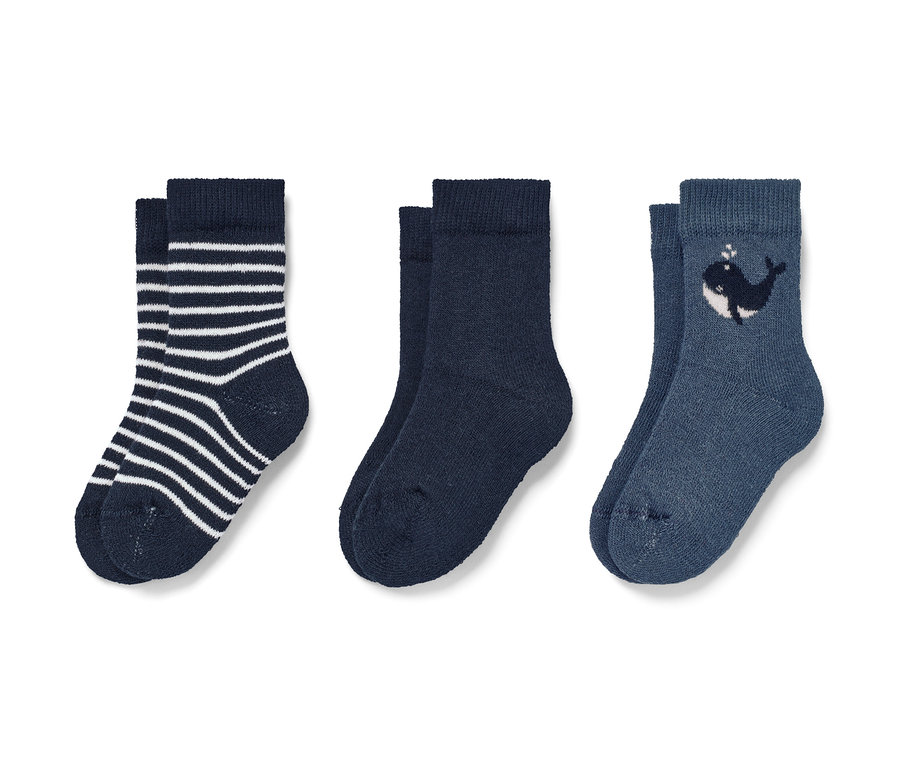 Drei Paar Babysocken: ein Paar gestreift, ein Paar dunkelblau, ein Paar mit Wal.