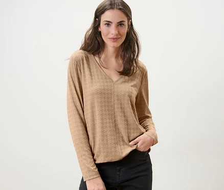 Frau posiert in einem strukturierten Langarmshirt, camel.