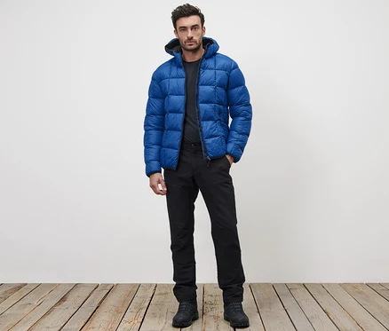 Mann steht und trägt eine blaue Steppjacke.