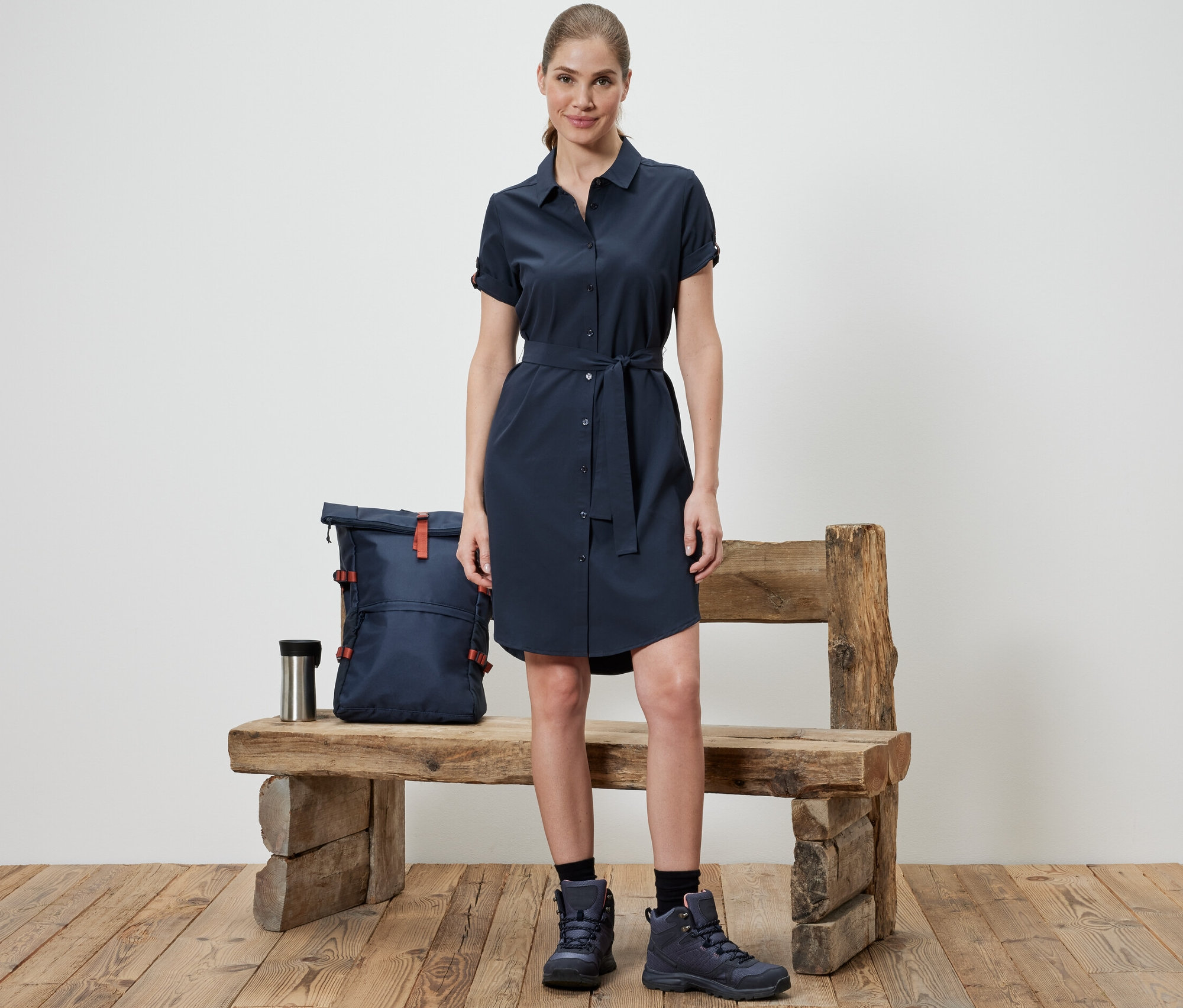 Frau steht vor einer Bank und trägt ein Funktions-Kleid.