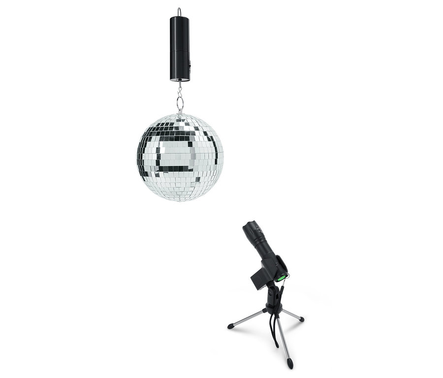 Eine Spiegelkugel hängt von der Decke neben einem Licht auf einem Stativ.