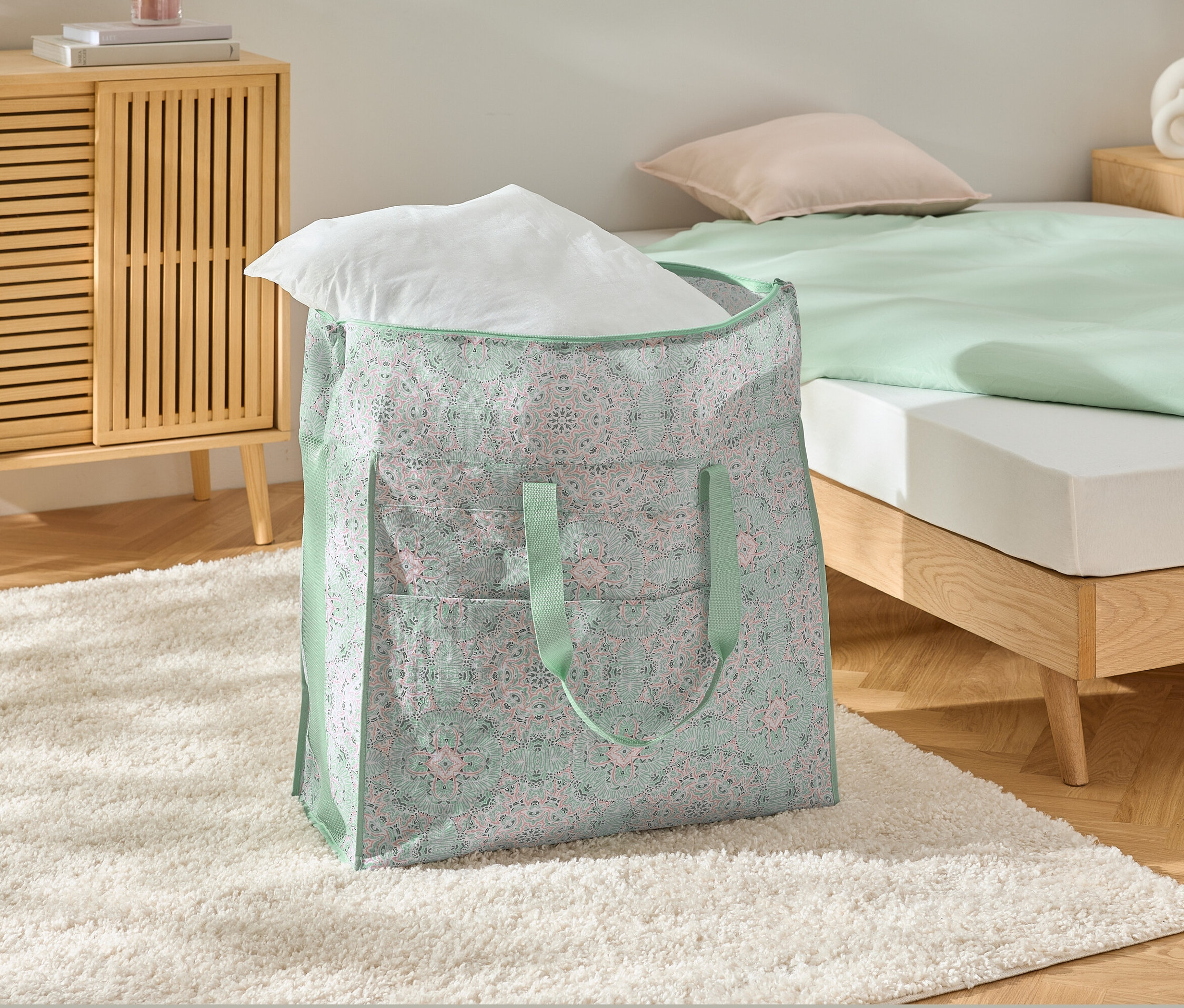 Eine Jumbo-Bettwarentasche mit einem weißen Kissen auf einem weißen Teppich.