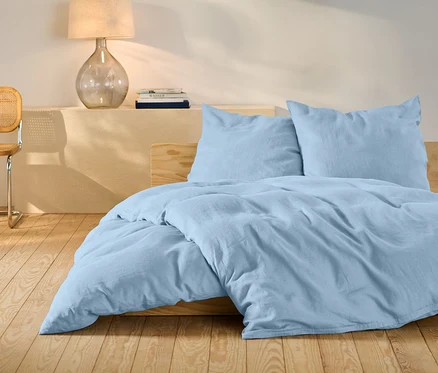 Helles blaues Leinen-Bettwäsche-Set in Standardgröße auf einem Bett.