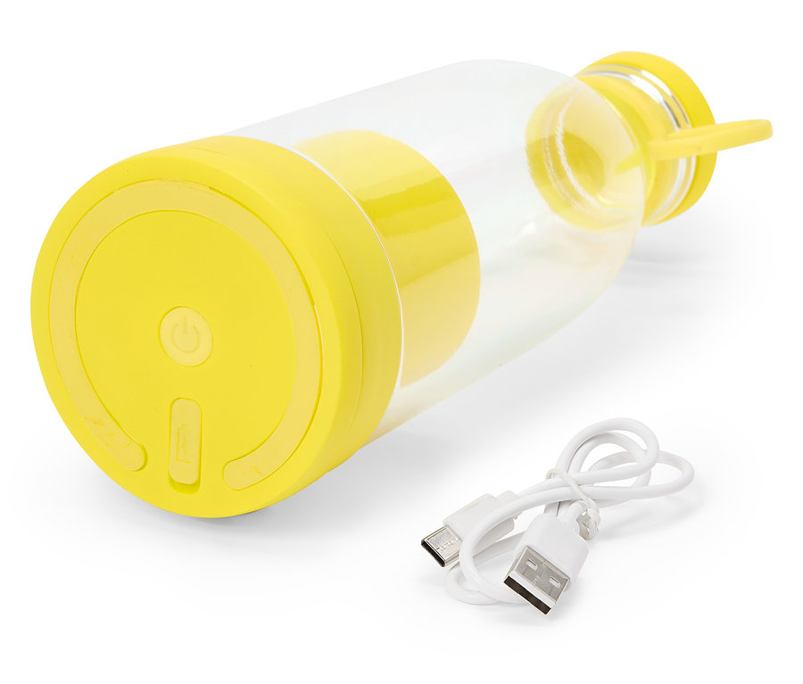 Ein gelber, tragbarer Mixer liegt auf einer weißen Oberfläche, zusammen mit einem weißen USB-Ladekabel.