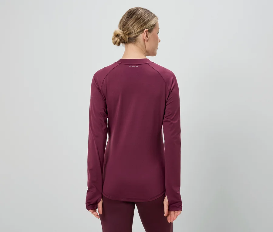 Rückansicht einer Frau mit Duttfrisur, die ein weinrotes, langärmliges Sportoberteil und Leggings trägt.