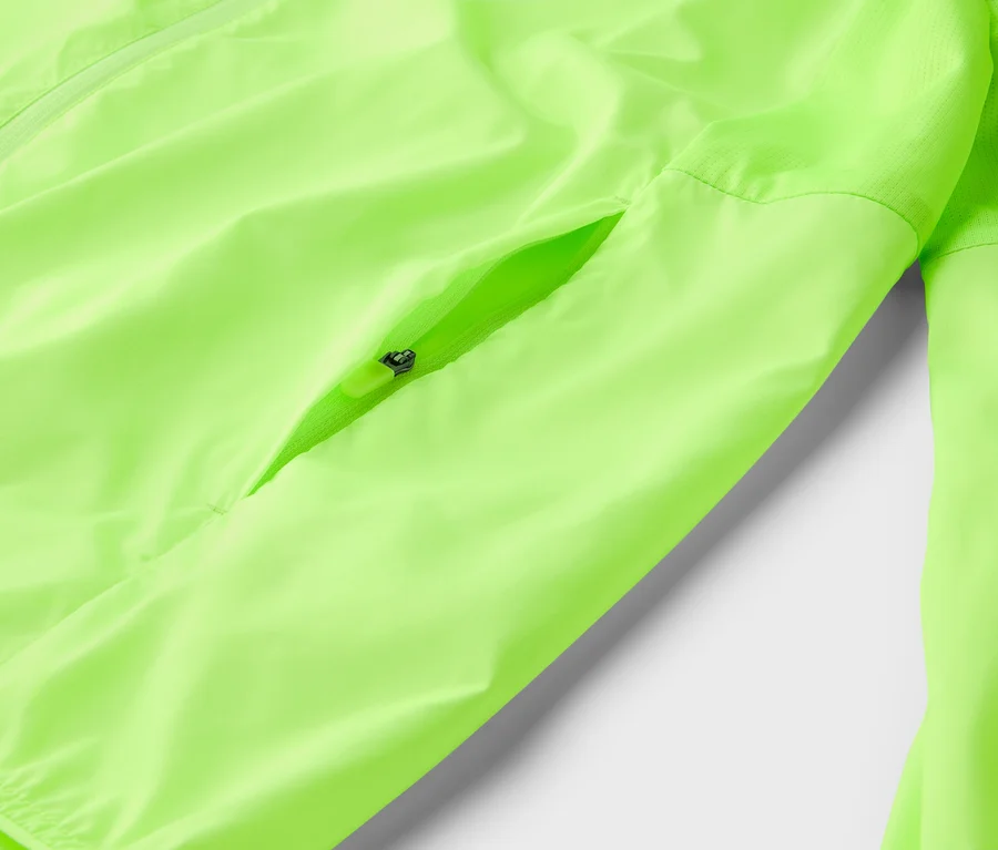 Nahaufnahme einer neongelben Jacke mit Reißverschluss und einer Reißverschlusstasche.