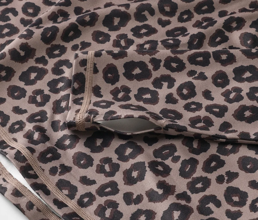 Nahaufnahme eines Sportoberteils mit Leopardenmuster und einer Tasche am Ärmel.