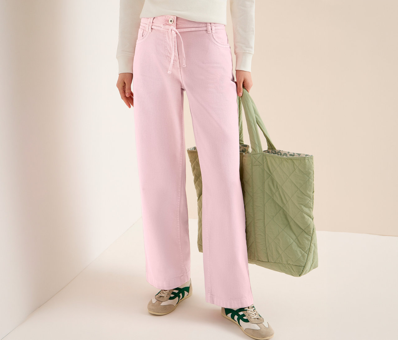 Frau mit CECIL Jeans »Neele« in Rosa und grüner Stofftasche. Sie trägt dazu Turnschuhe.