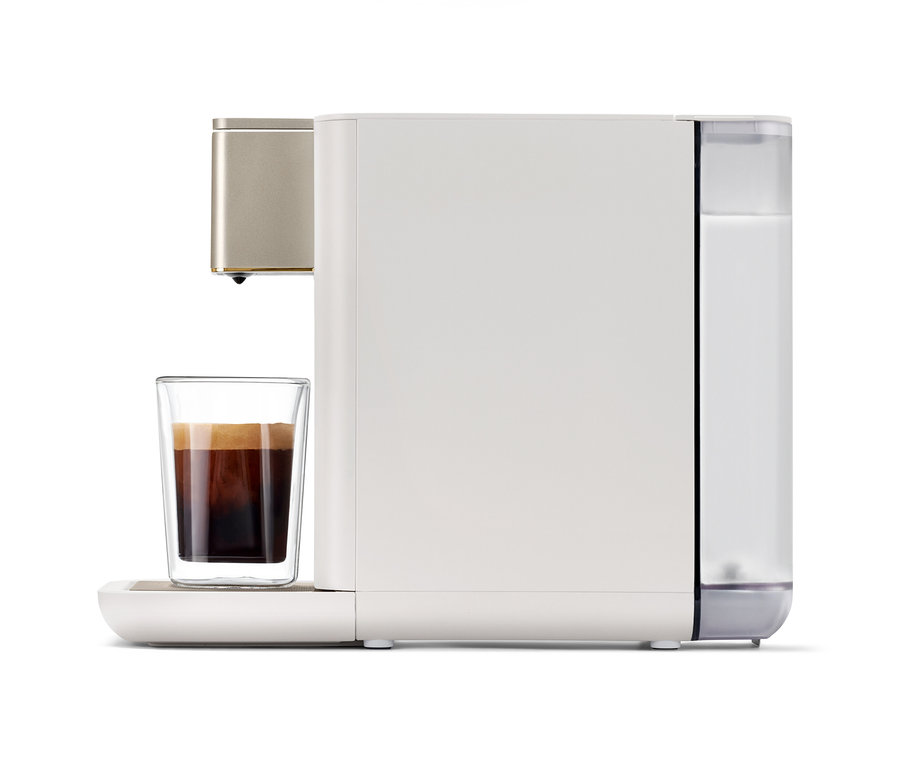 Qbo ICONIC Light Gold Kaffeemaschine bereitet Kaffee in einem Glas zu.