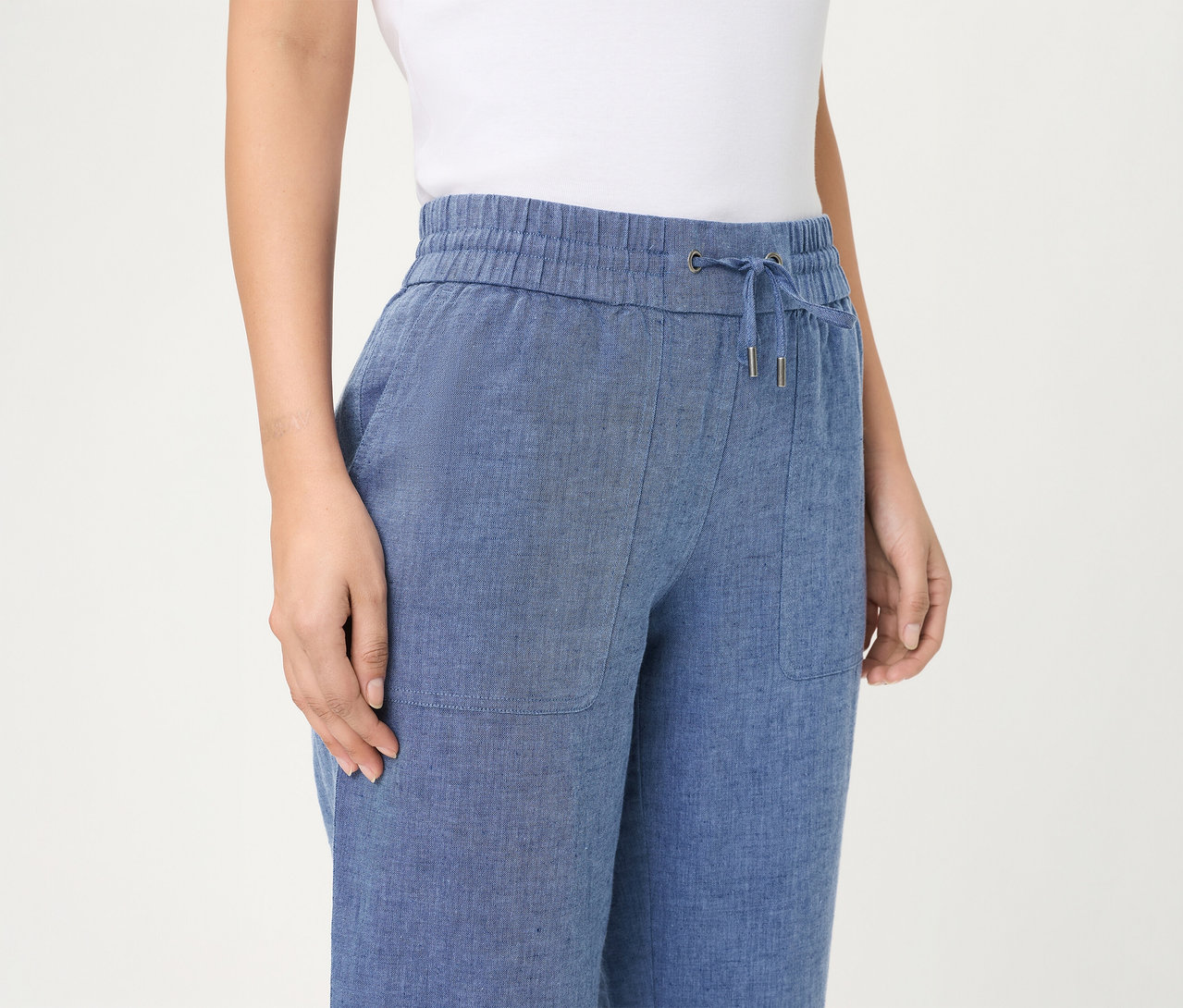 Person trägt eine blaue Olsen Jeans cropped mit elastischem Bund, Kordelzug und aufgesetzten Taschen.
