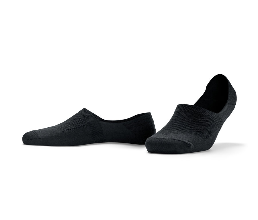 Zwei Paar schwarze Sport-Füßlinge liegen auf dem Boden.