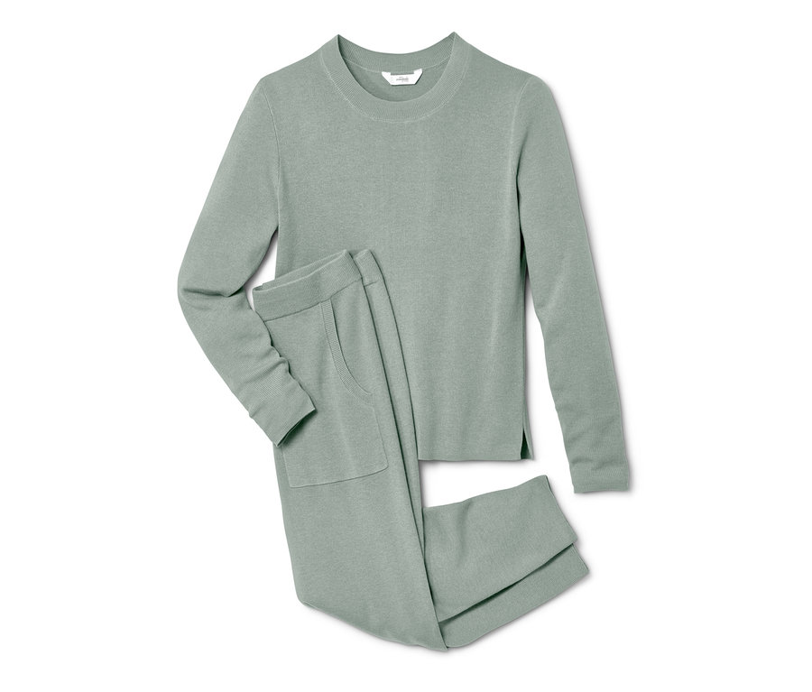 Ein grüner Hausanzug aus Strick, bestehend aus Pullover und Hose, liegt auf einem weißen Hintergrund.