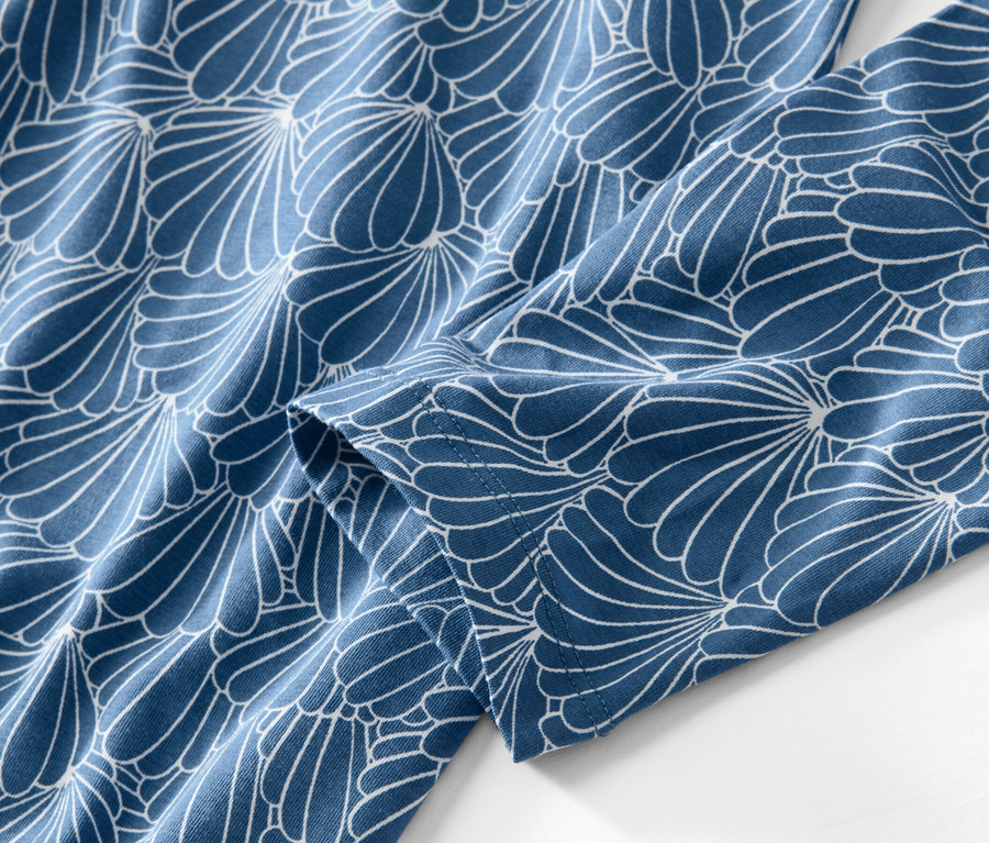 Detailansicht eines Nachthemds mit blau-weißem Blumenmuster.