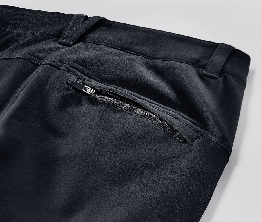Detailaufnahme einer schwarzen Cargo-Softshellhose mit Reissverschluss.