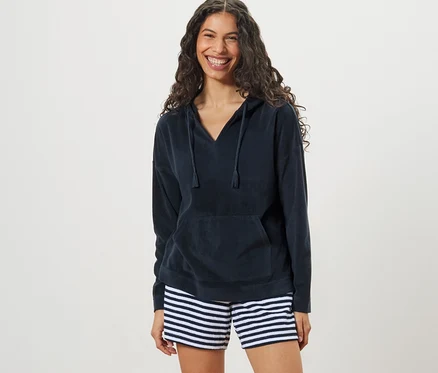 Frau trägt einen Frottee-Hoodie und gestreifte Shorts.