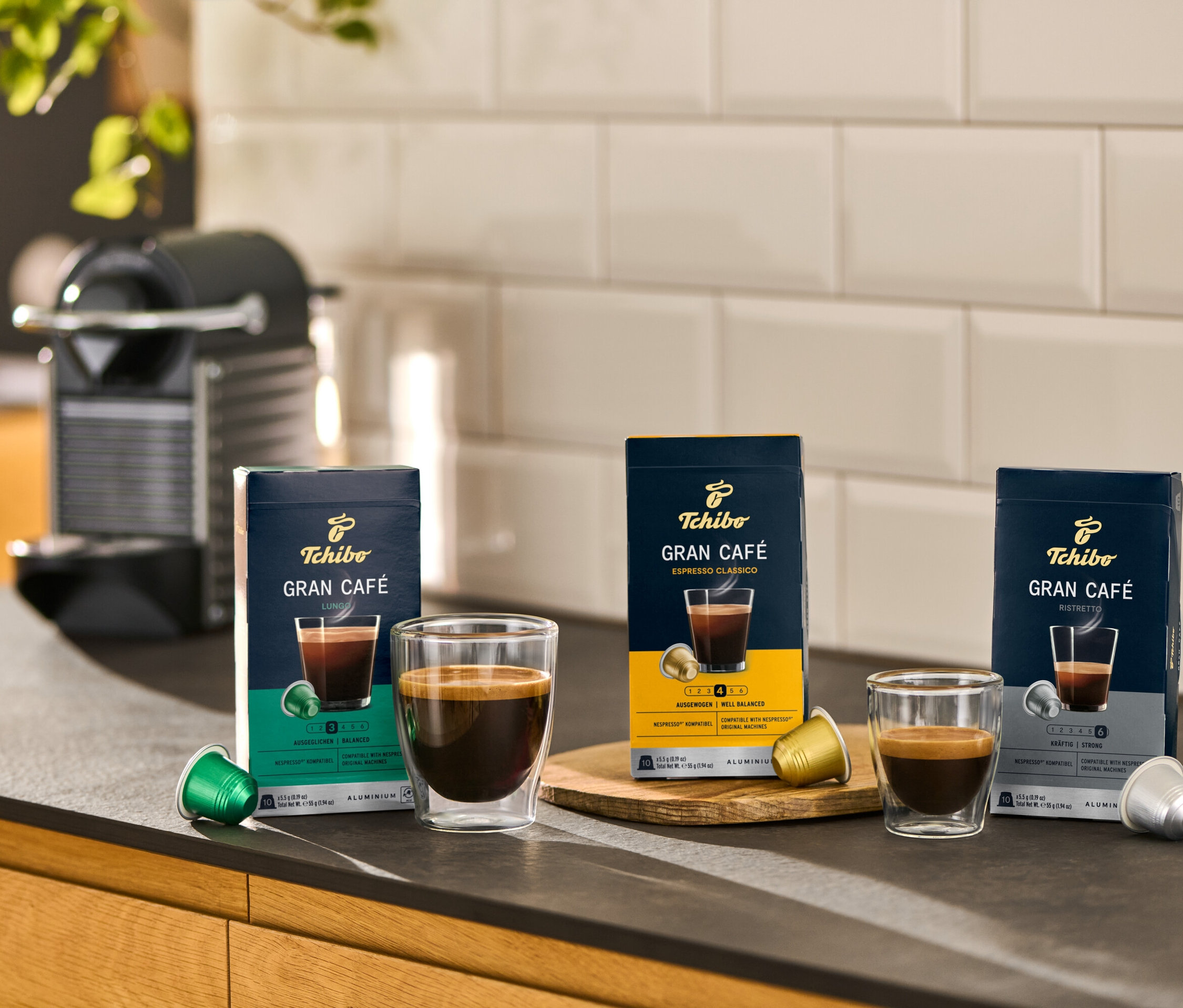 Aufnahme von Gran Café Ristretto Kaffeekapseln und Tassen auf einer Küchentheke.