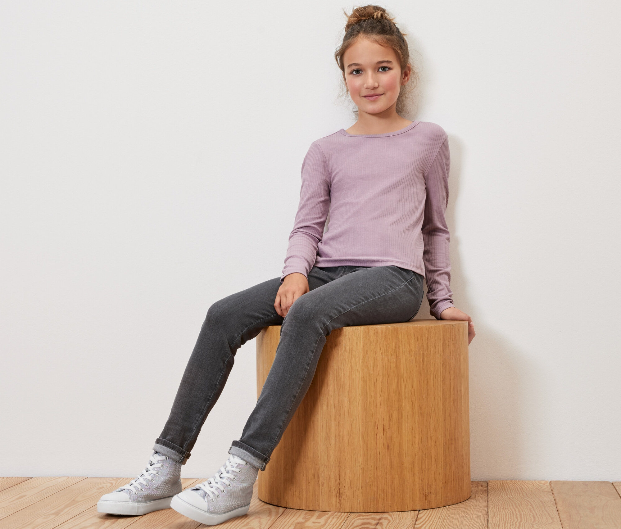 Mädchen sitzt auf einem Holzhocker und trägt Kinder-Treggings – Fit »Jule«.