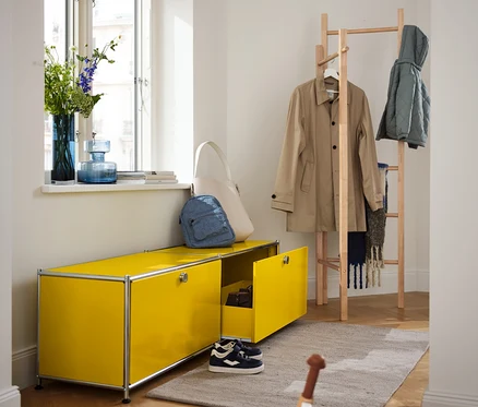 Gelbes Lowboard Metall »CN3« mit Schubladen neben einer Kleiderleiter.
