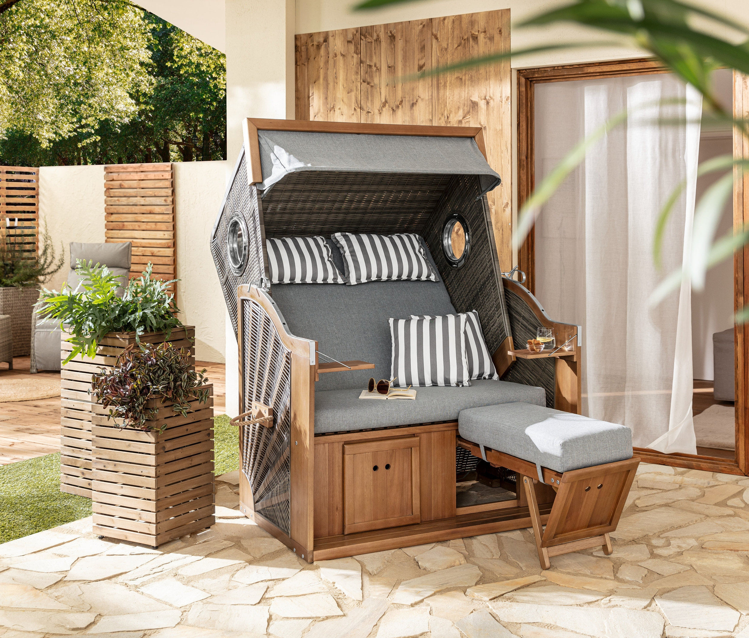 Zwei Pflanzsäulen »Tinus« stehen neben einem Premium-Strandkorb XL mit 2 Ausklapptischen.