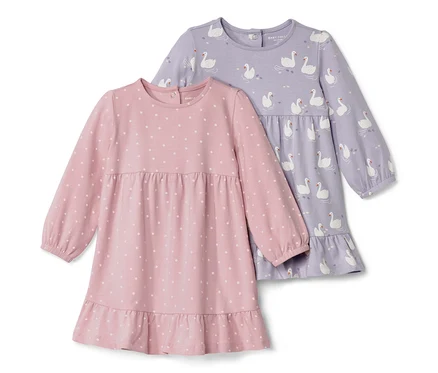 Zwei Baby-Jerseykleider: Eines ist rosa mit weißen Punkten, das andere lila mit Schwanenmuster.
