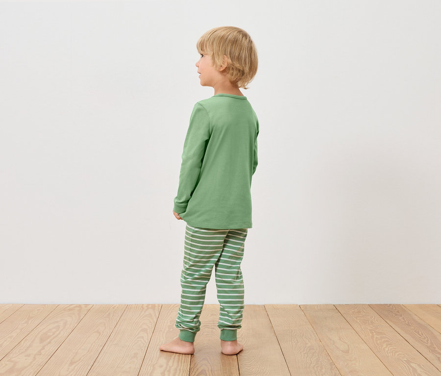 Junge im grünen Pyjama schaut nach links.