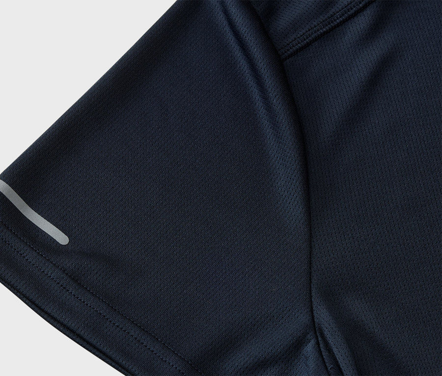Nahaufnahme eines marineblauen Sportshirts mit Mesh-Textur und reflektierendem Streifen am Ärmel.
