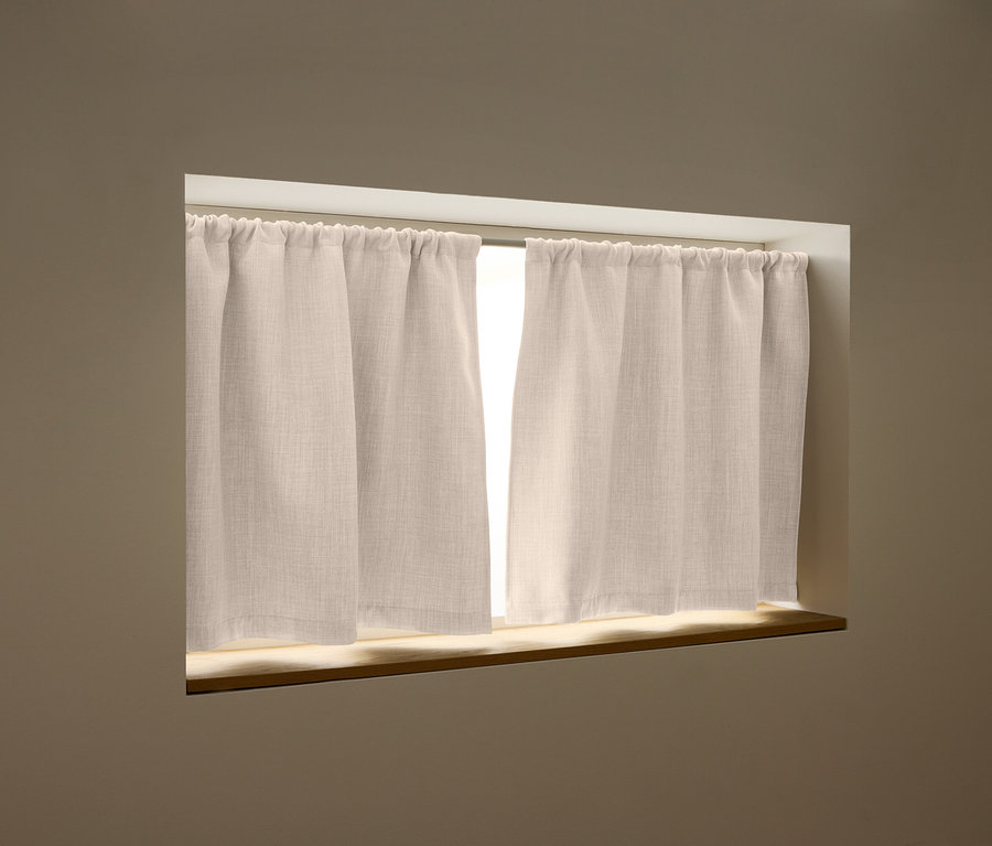Zwei beige Vorhänge hängen an einer Gardinenstange vor einem Fenster.