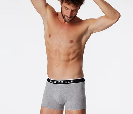 Mann mit Händen hinter dem Kopf, trägt graumelierte SCHIESSER Shorts.