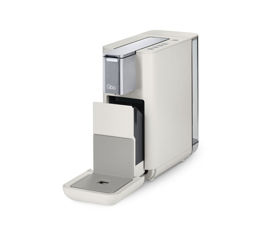Qbo ESSENTIAL Bright Sand Kaffeemaschine mit offenem Kapselbehälter.