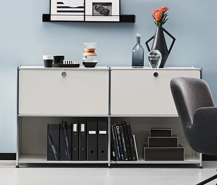 Ein Zimmer mit einem anthrazitfarbenen Schreibtischstuhl und Metall-Sideboards. Ein anthrazitfarbenes und zwei weiße Metall-Sideboards CN3 mit 2 versetzbaren Klappenfächern.