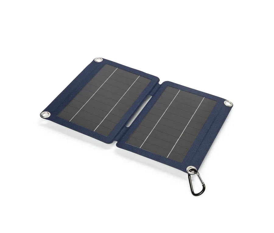 Aufgeklapptes blaues Solarpanel mit Karabinerhaken liegt auf einem weißen Untergrund.