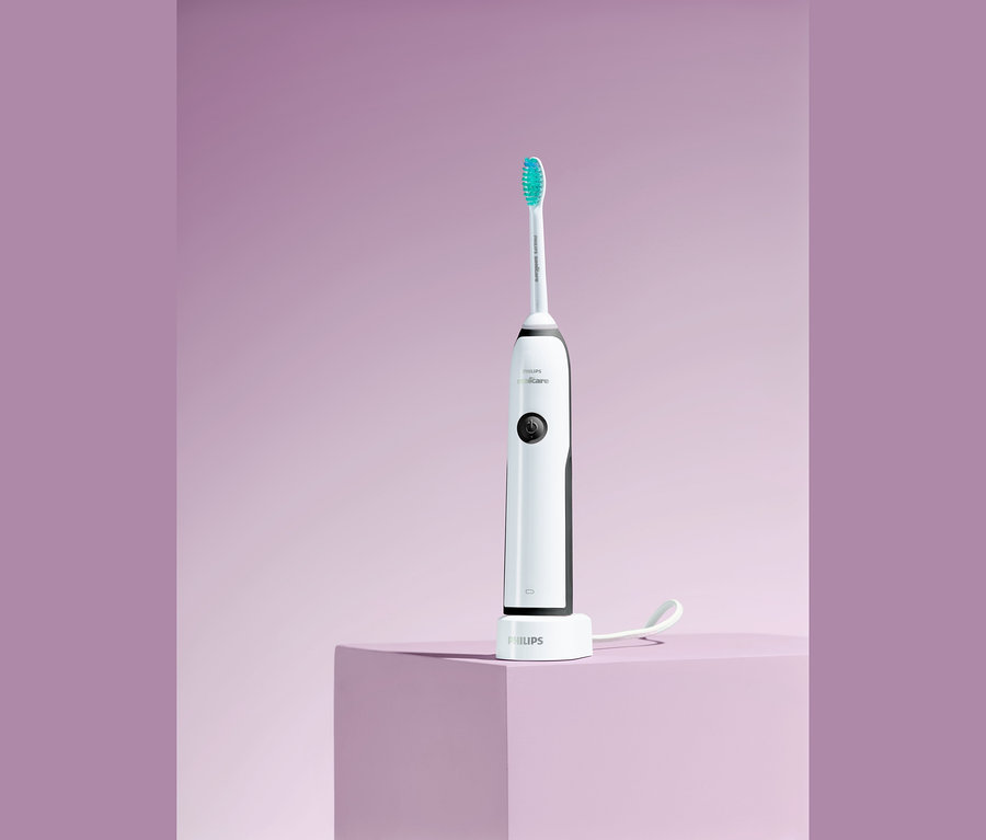 Elektrische Schallzahnbürste Philips Sonicare CleanCare+ HX3212/56 auf lila Hintergrund.
