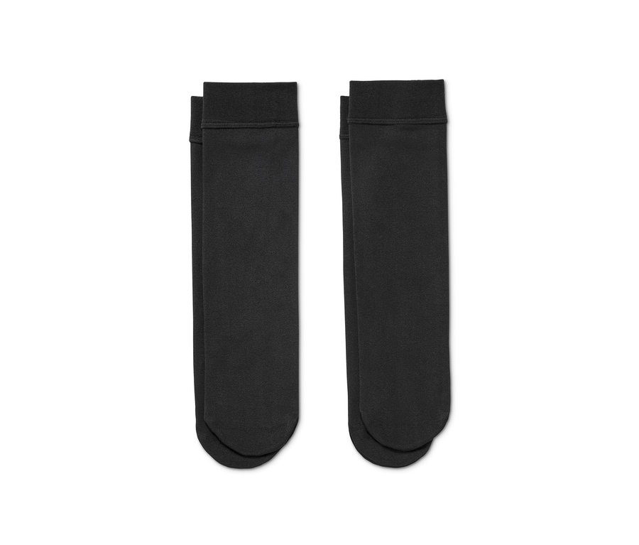 Zwei Paar schwarze Thermokniestrümpfe liegen nebeneinander.