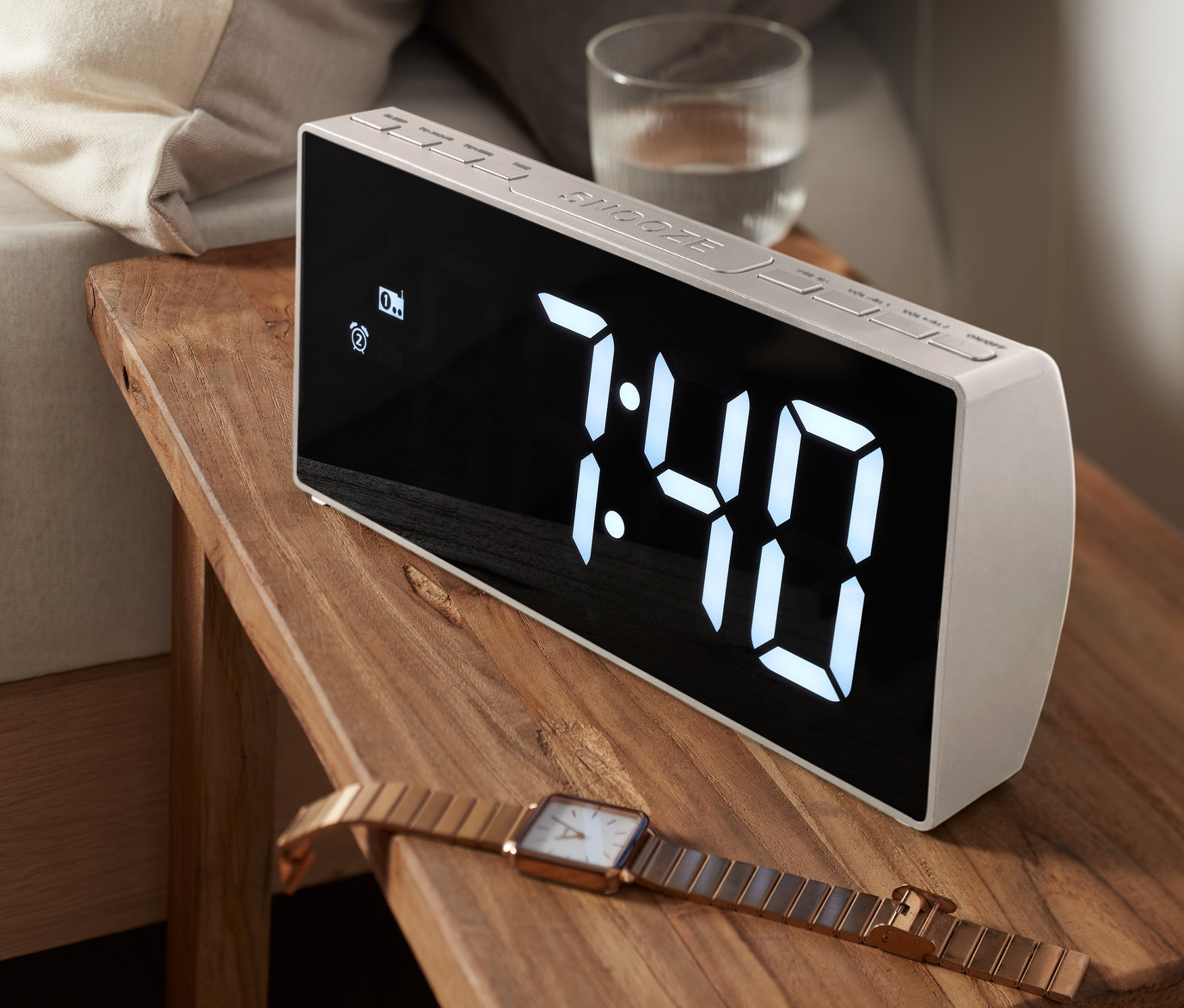 Ein XXL-Radiowecker steht auf einem Nachttisch neben einem Bett. Die Uhrzeit auf dem Display ist 7:40.