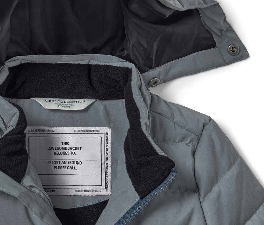 Detailaufnahme einer reflektierenden Kinder-Steppjacke in Grau mit Kapuze.