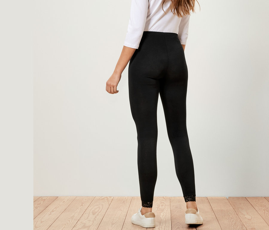 Frau von hinten trägt Leggings mit Spitzenborte, weißes Oberteil und weiße Sneaker.